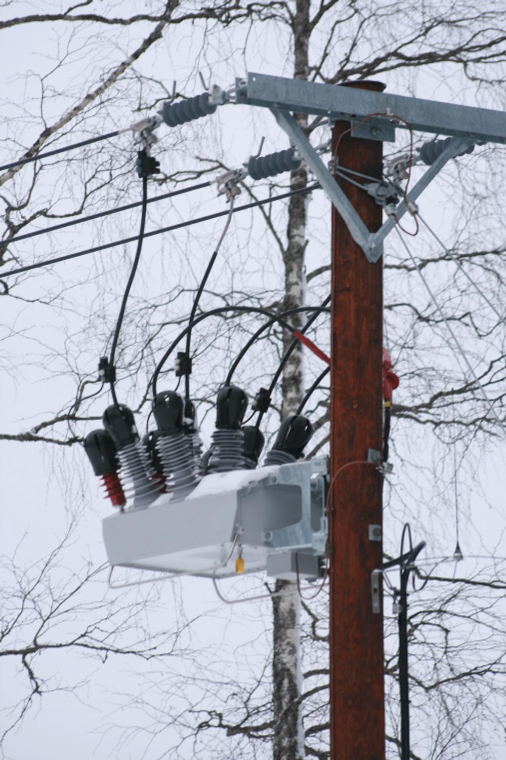 Close up of NOJA Power OSM Recloser installation in Sweden with snow covered trees in the background