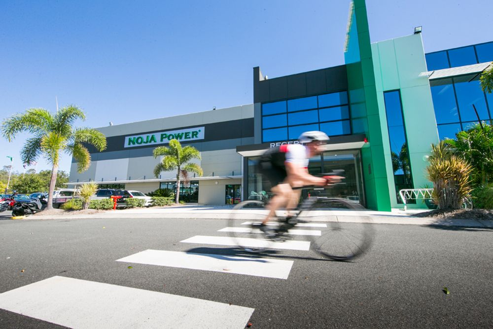 Man on bike riding in front of NOJA Power Headquarters in Brisbane, Australia