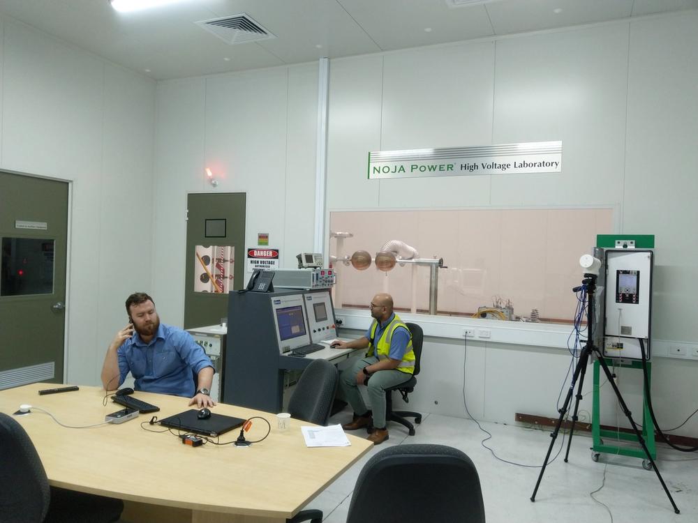 NOJA Power’s test laboratory with Factory Acceptance Testing (FAT) capability, with one man sitting at a table and another sitting at the testing station