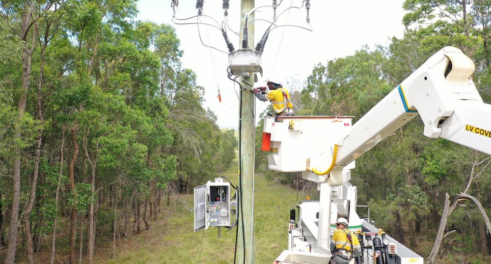 Lineworker being lifted in a bucket truck to install a NOJA Power OSM Recloser and RC20 