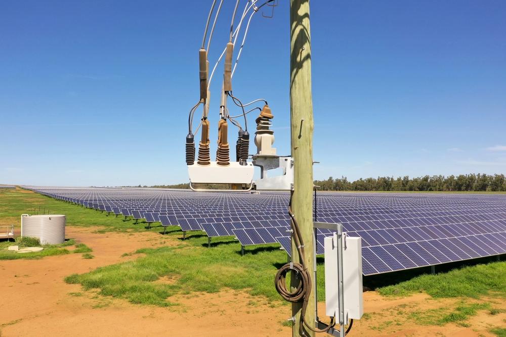 A NOJA Power OSM Recloser connecting Renewable Generation Energy to the Distribution Grid with a solar farm in the background