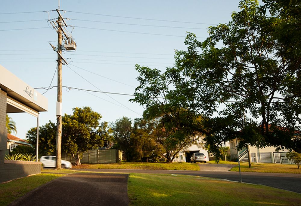 NOJA Power OSM Recloser on a suburban street with houses and cars in the background