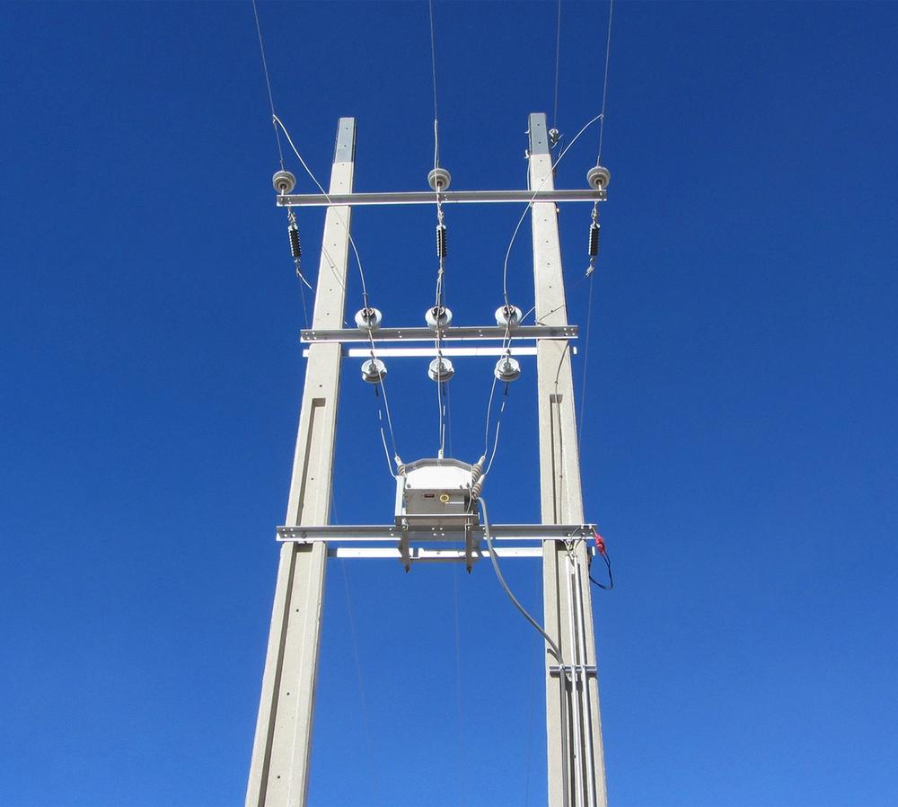 NOJA Power OSM Recloser taken from below with clear blue skies behind