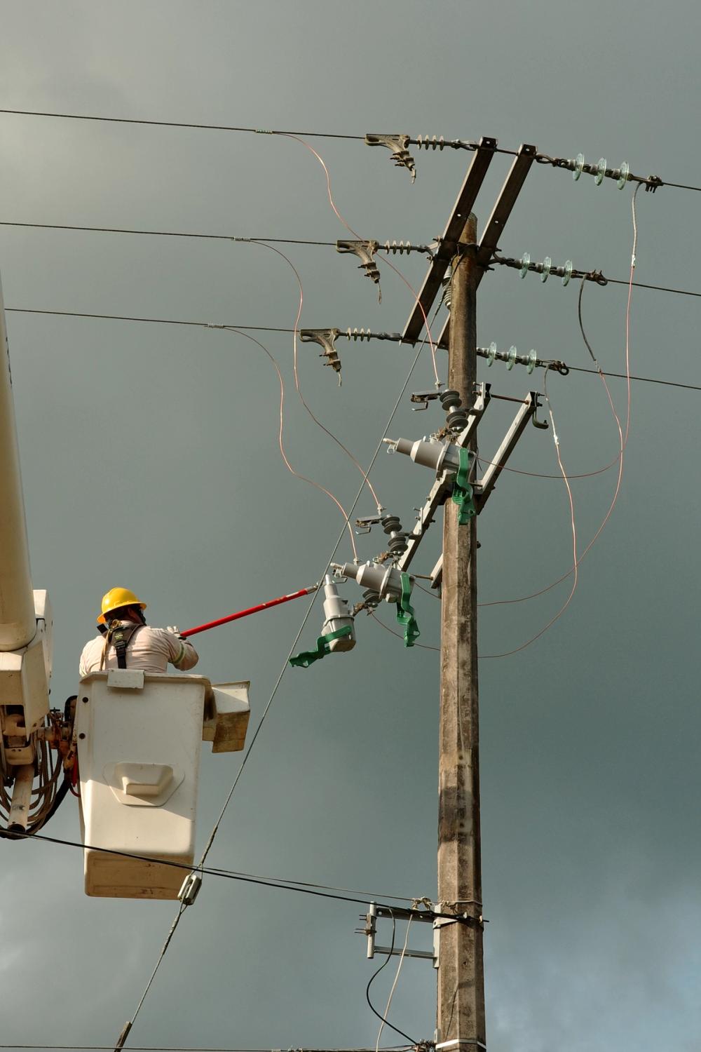 Network Operators closing the EcoLink into a fuse cutout in the Open Position. Once installed, the green interlock lever is closed, closing the EcoLink and preventing removal until the mechanical trip arm is pulled.