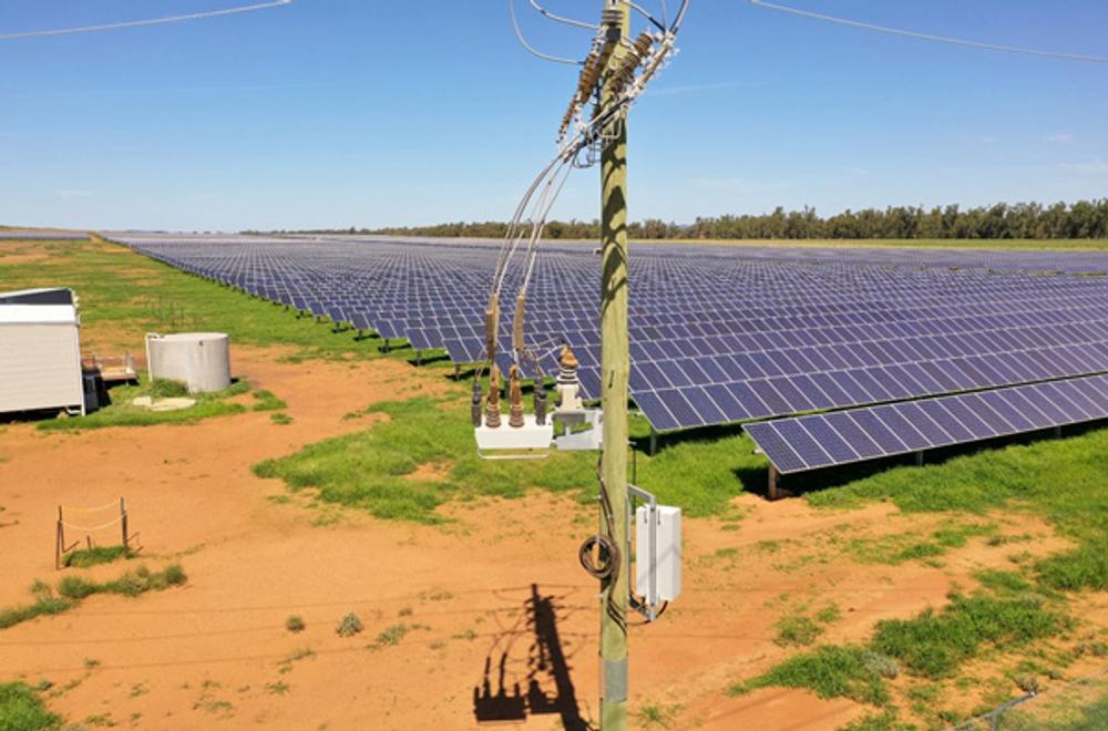 NOJA Power OSM Recloser in the centre forefront of the image, with red dirt and a solar farm in the background of the photo