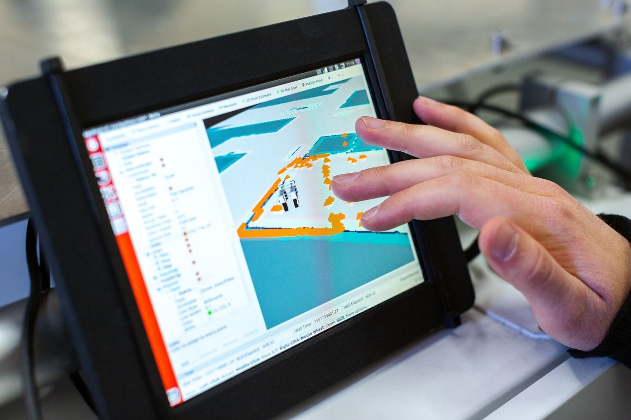 A hand touches a tablet screen showing a robot navigation map with orange markers and a settings panel