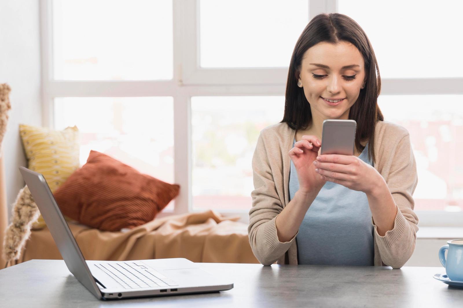 Tester reading a verification email on a smartphone while an automated test runs on her laptop