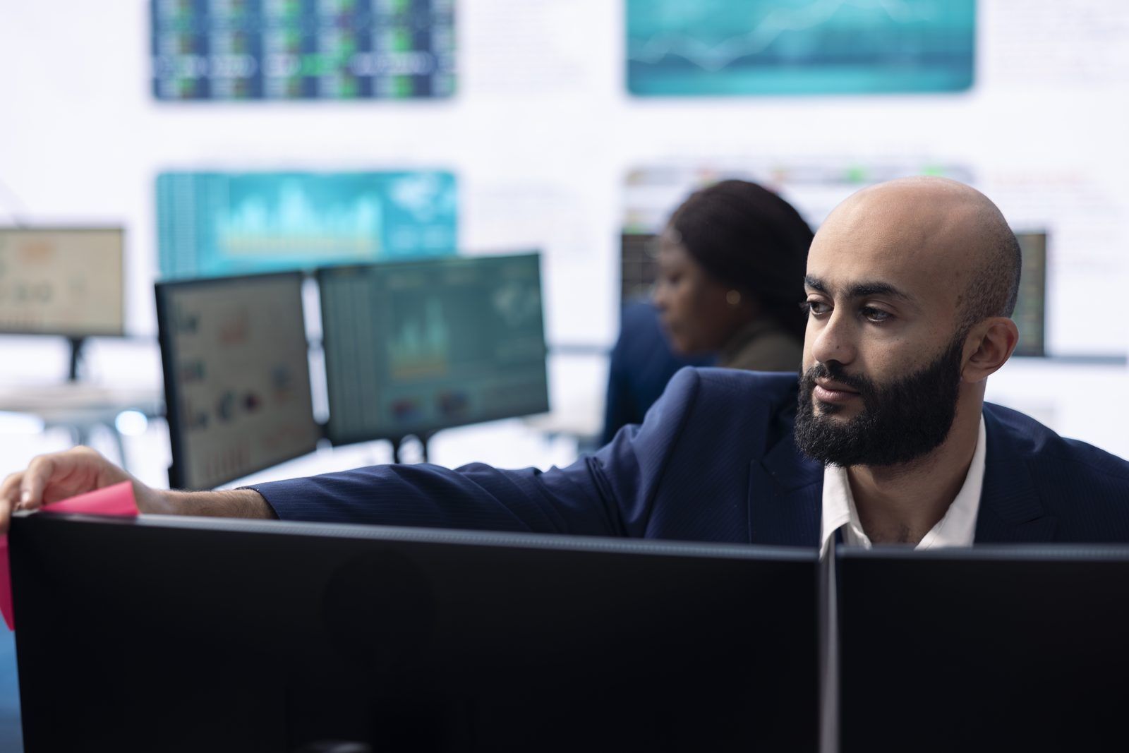 Operations manager monitoring live system dashboards before approving automated actions