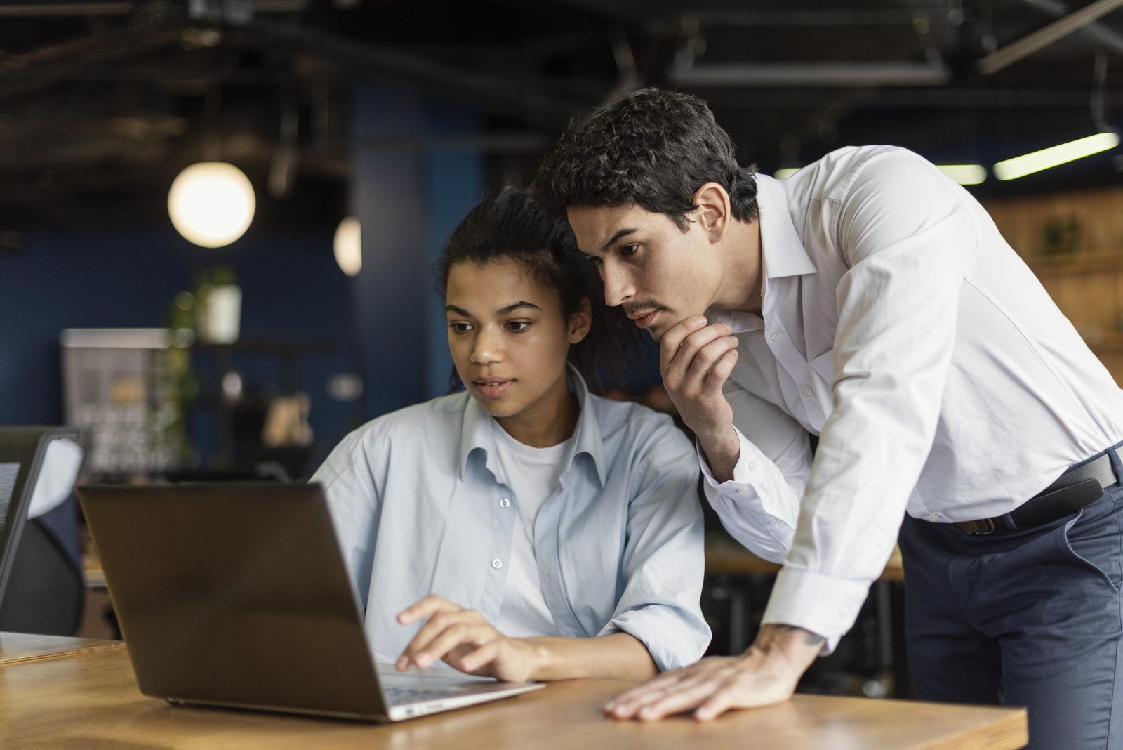 Developer and team lead checking generated code on a laptop during a pilot review