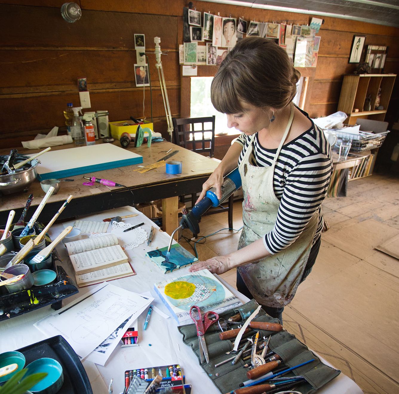 Portrait of Natalie Salminen Rude in an art studio, working on an encaustic painting.