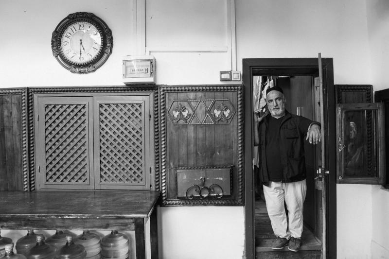 A man stood on a phonecall in the entrance to the inner house of the Dergah