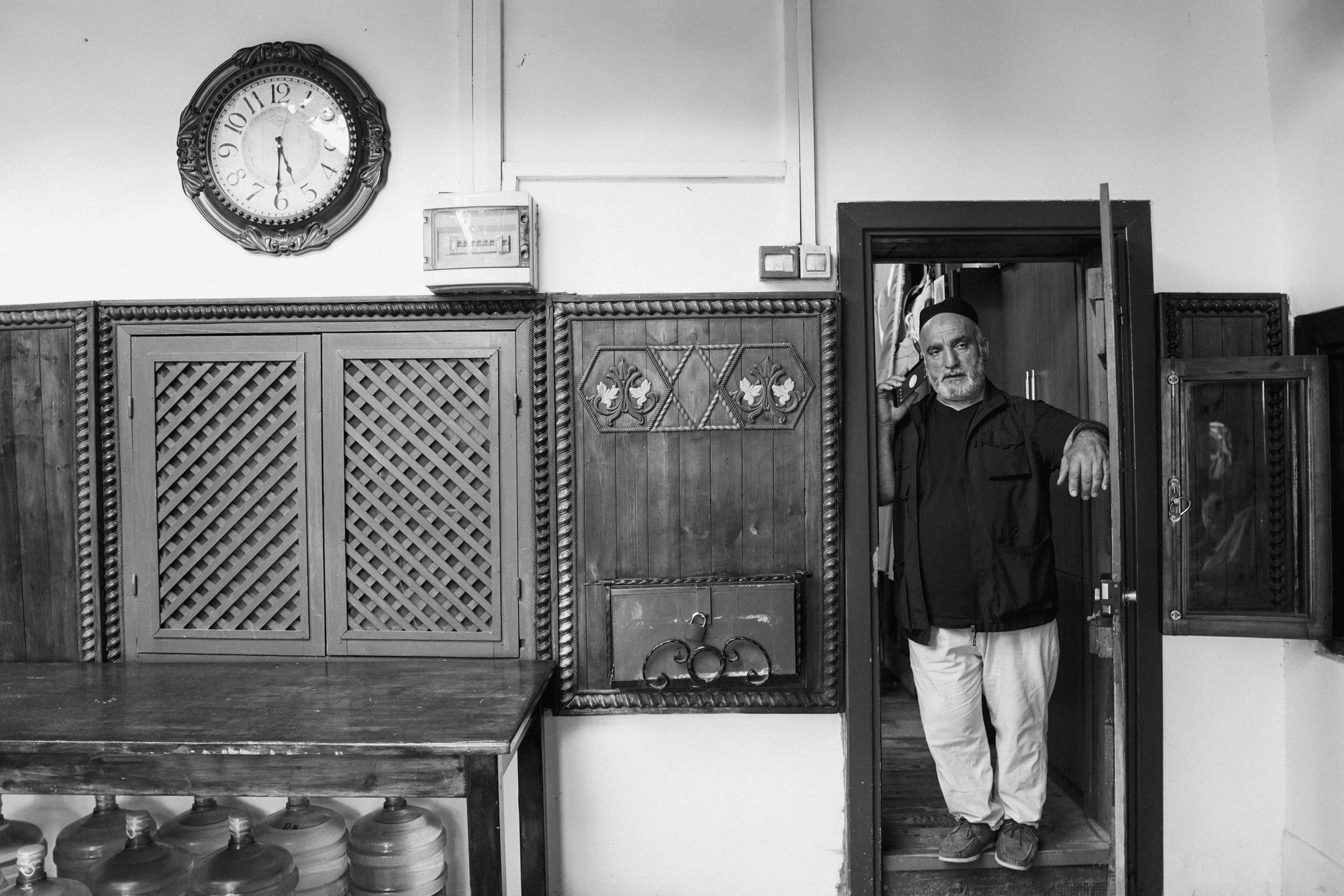 A man answering a phone call in a doorway.