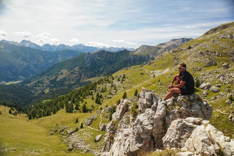 A man sat on a rocky cliff edge