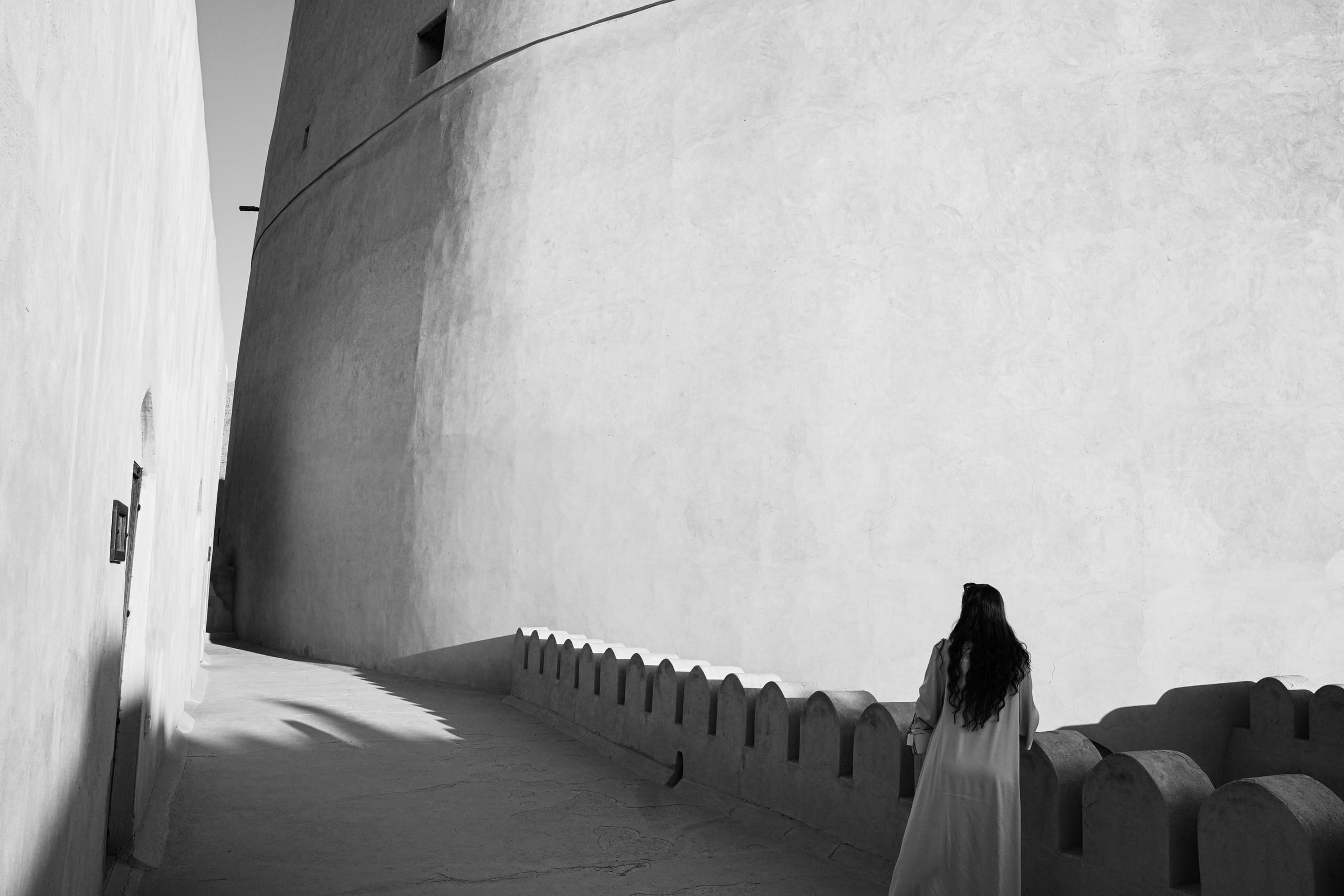 The curved outer wall of the fort, abrupted by the linear angles of a walkway