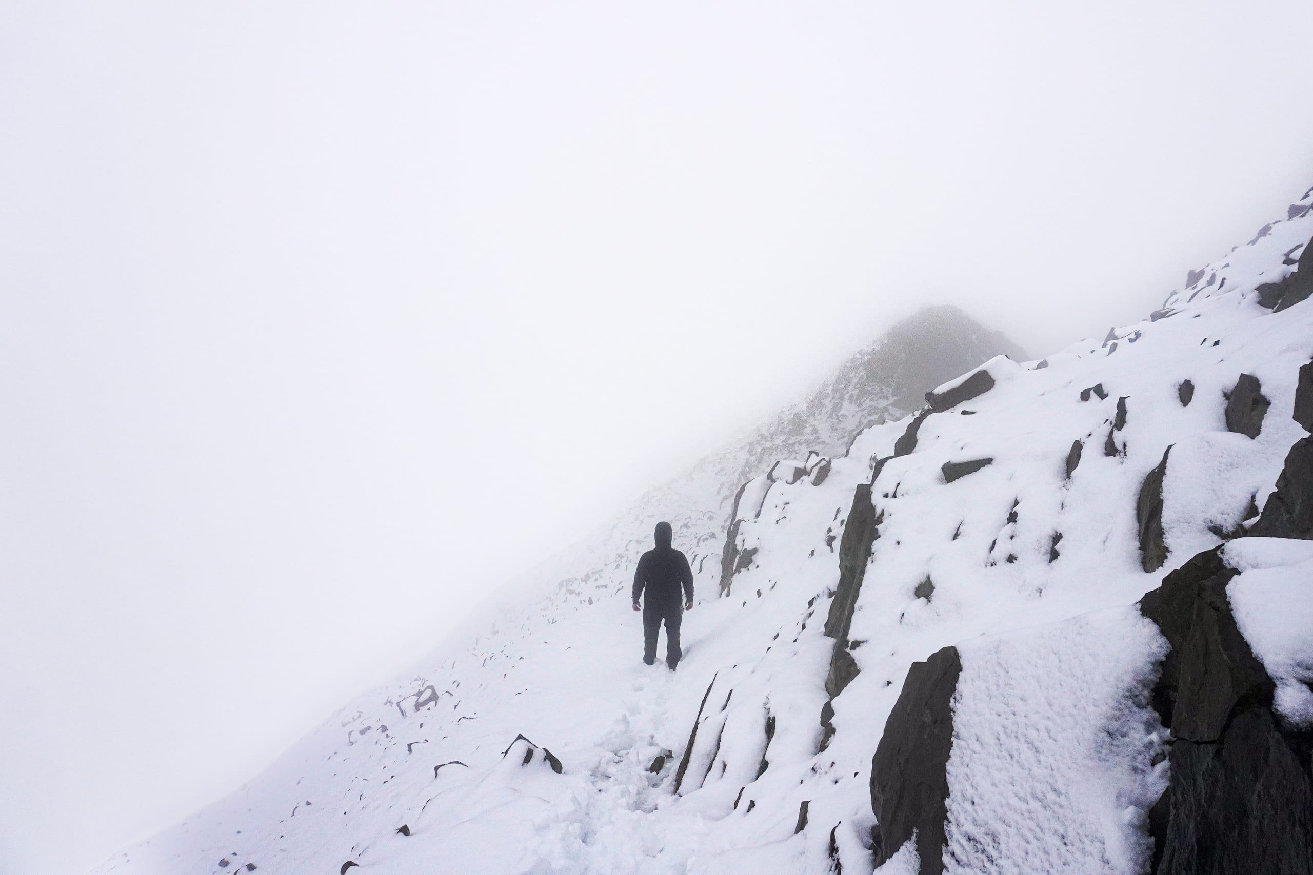 Foggy descent down a stark ridge