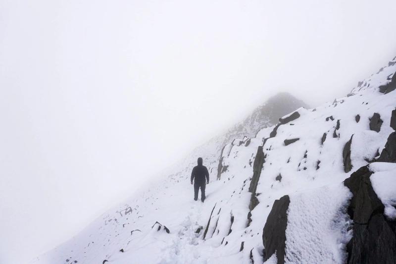 Foggy descent down a stark ridge