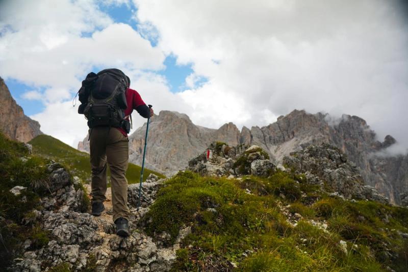 Hiker from behind, ascending a mountain