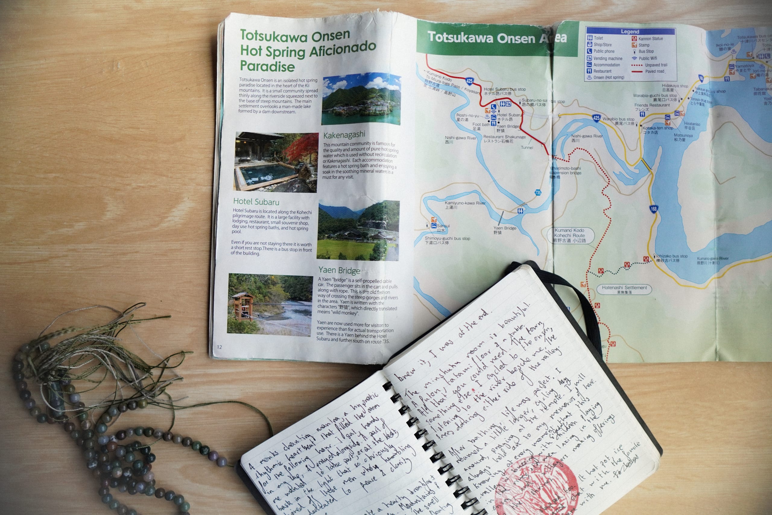 diary, prayer beads and a map strewn acoss a table