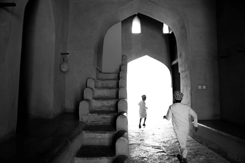 Two children run through a corridor.