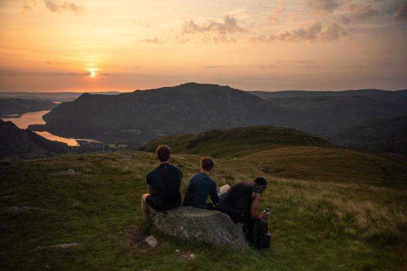 Three hikers watchign the sunrise over ullswater