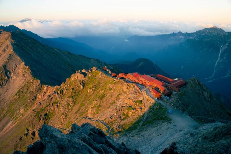 The mountain hut, nestled in the mountains, from atop Yarigatake