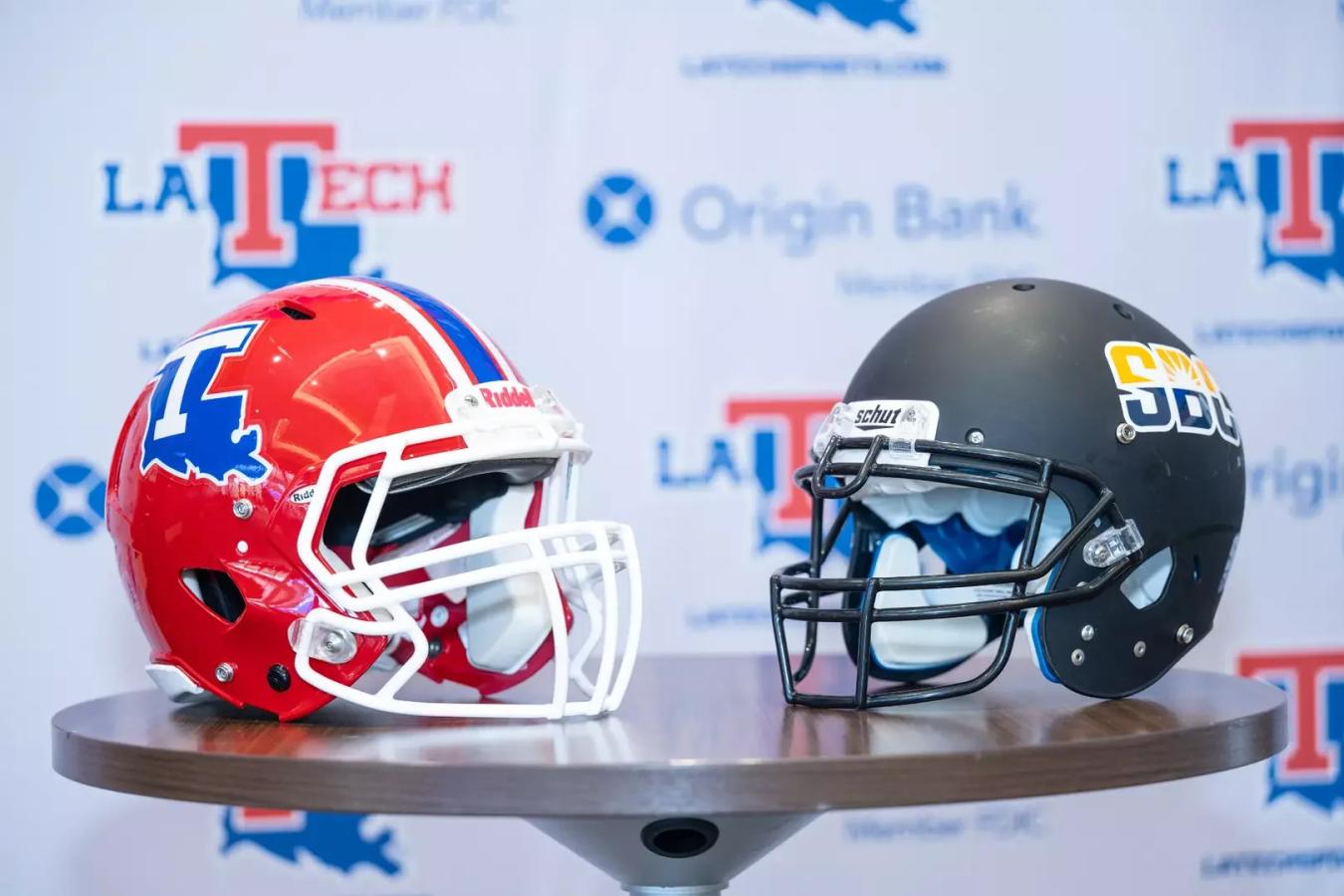 Louisiana Tech football helmet next to a Sun Belt football helmet on a table at the press conference on July 16, 2025.