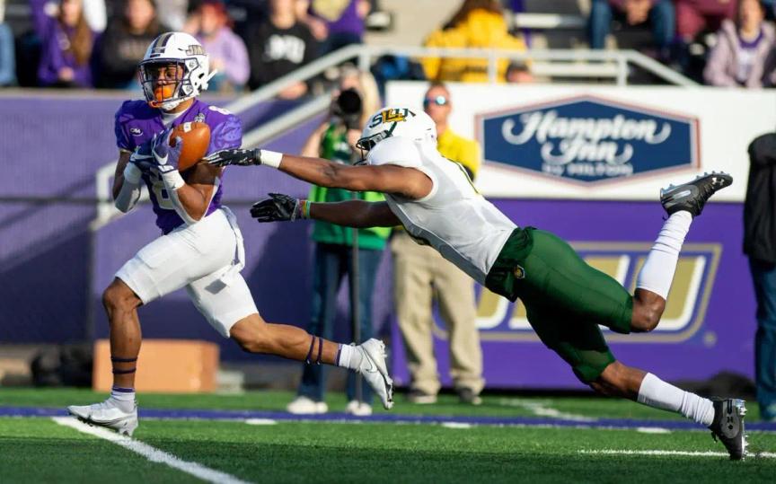 James Madison wide receiver Kris Thornton (8) hauls in a pass under pressure from Southeastern Louisiana defensive back Markell Linzer (13) during the first half of an NCAA football second-round playoff game in Harrisonburg, Va., Saturday, Dec. 4, 2021.