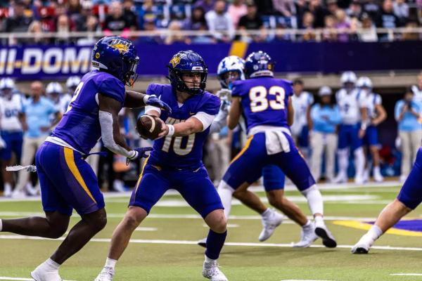 Northern Iowa QB Aidan Dunne hands the ball off during their game against Indiana State
