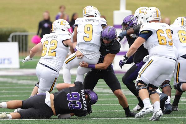 A Furman defender tackles UTC's QB Hutchinson