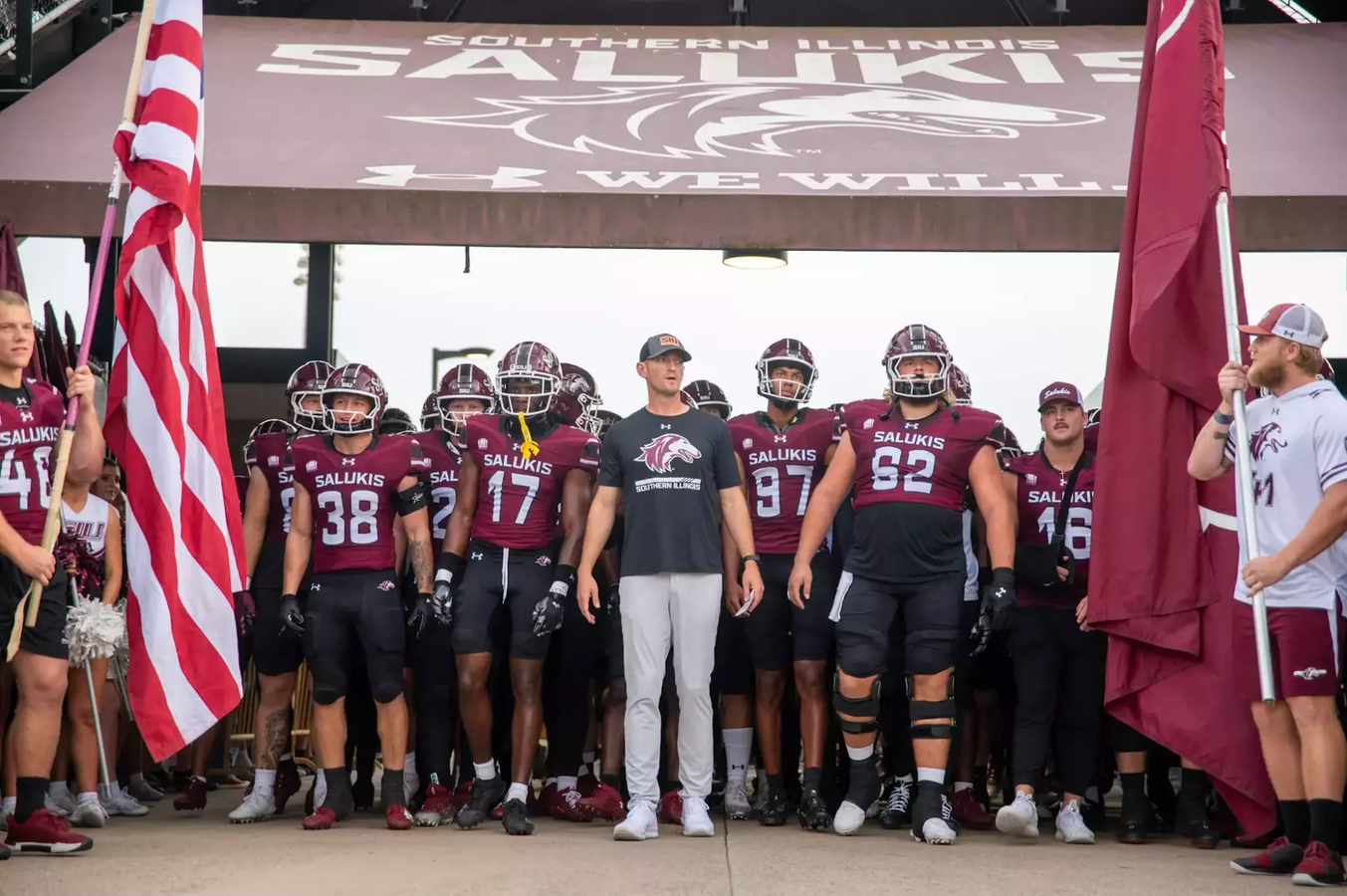 Southern Illinois Football Head Coach leads the team into the stadium