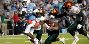 North Carolina's George Pettaway (23) evades Florida A&M's Eric Smith (8), Gentle Hunt (92) and Justin Cooks (57) en route to a touchdown during the second half of an NCAA college football game in Chapel Hill, N.C., Saturday, Aug. 27, 2022.