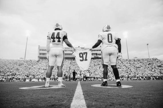 Captains Luke Clark (No. 44) and Jeremiah Jackson (No. 0) display Bryce Stanfield's No. 97 jersey in fitting tribute as they walk out for the coin flip last Saturday vs. Ole Miss
