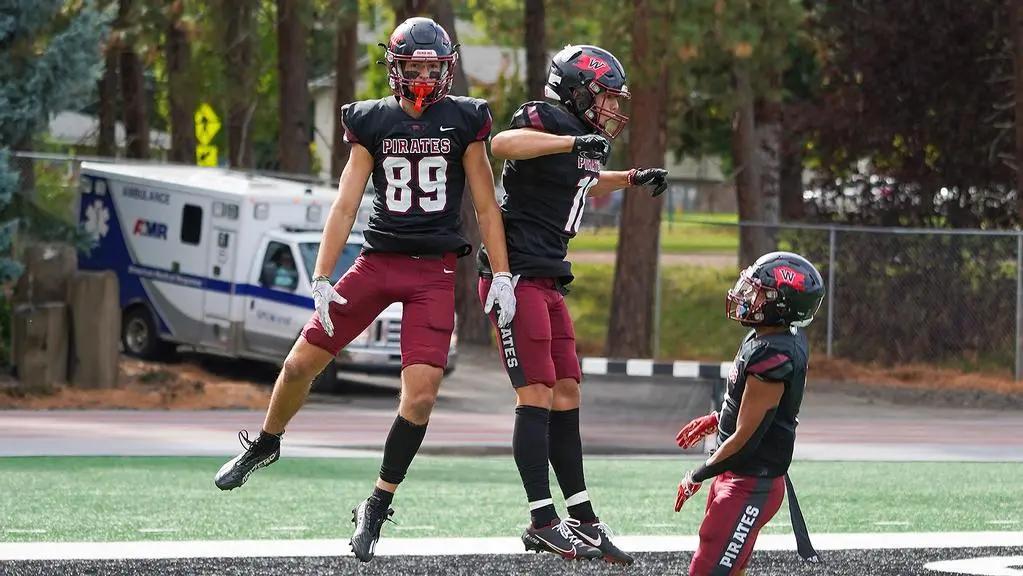 Whitworth Pirates football players celebrating after a big play