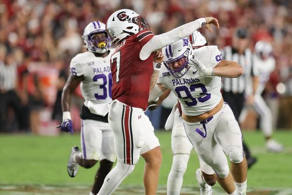 Furman's DE Jack Barton and SPUR Jalen Miller pressure South Carolina's QB Spencer Rattler
