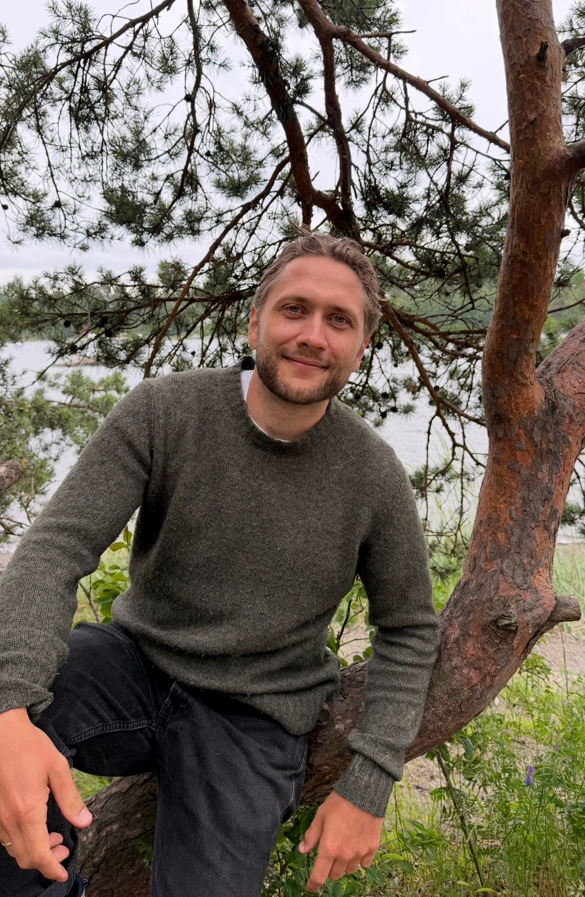 Bilde av Sebastian inntil et tre ved sjøen
