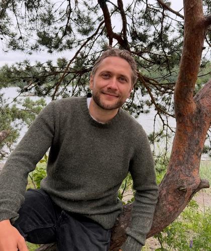 Bilde av Sebastian inntil et tre ved sjøen