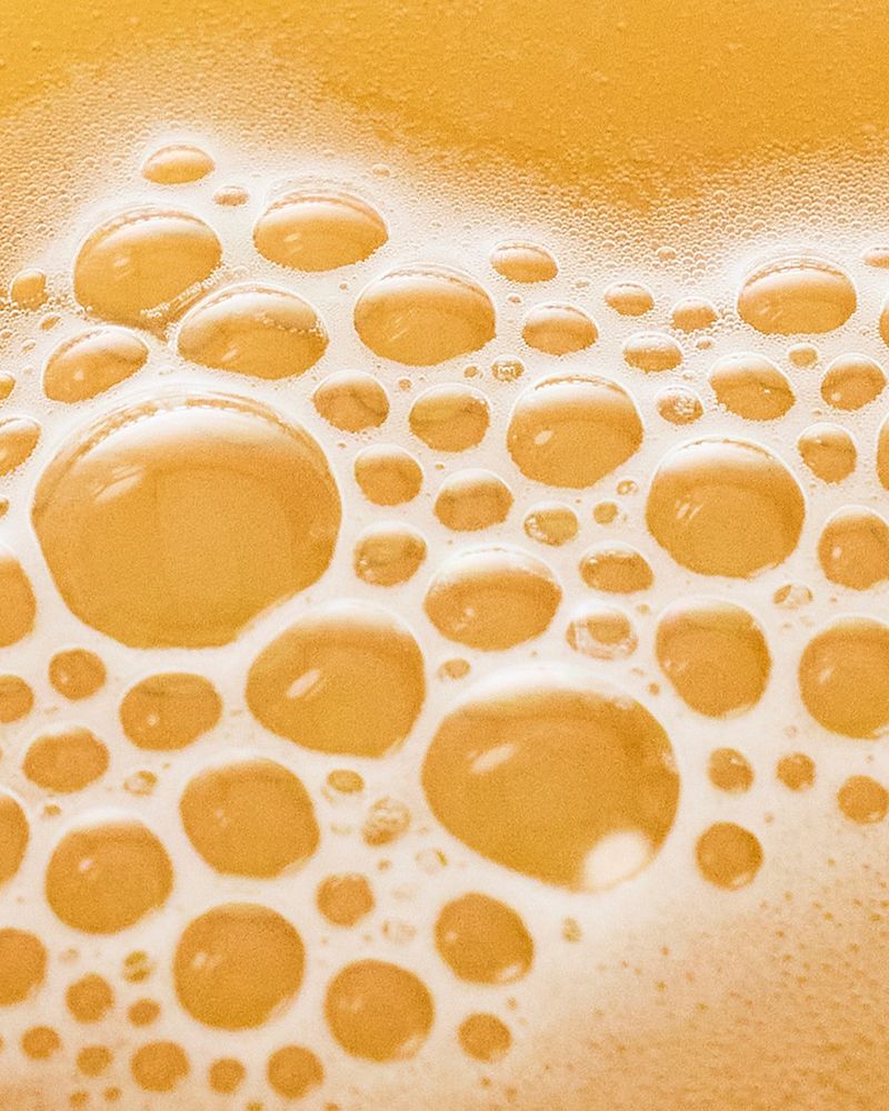 Close-up of the golden, bubbly surface of Villbrygg ENG – a non-alcoholic, fermented drink made with natural ingredients.