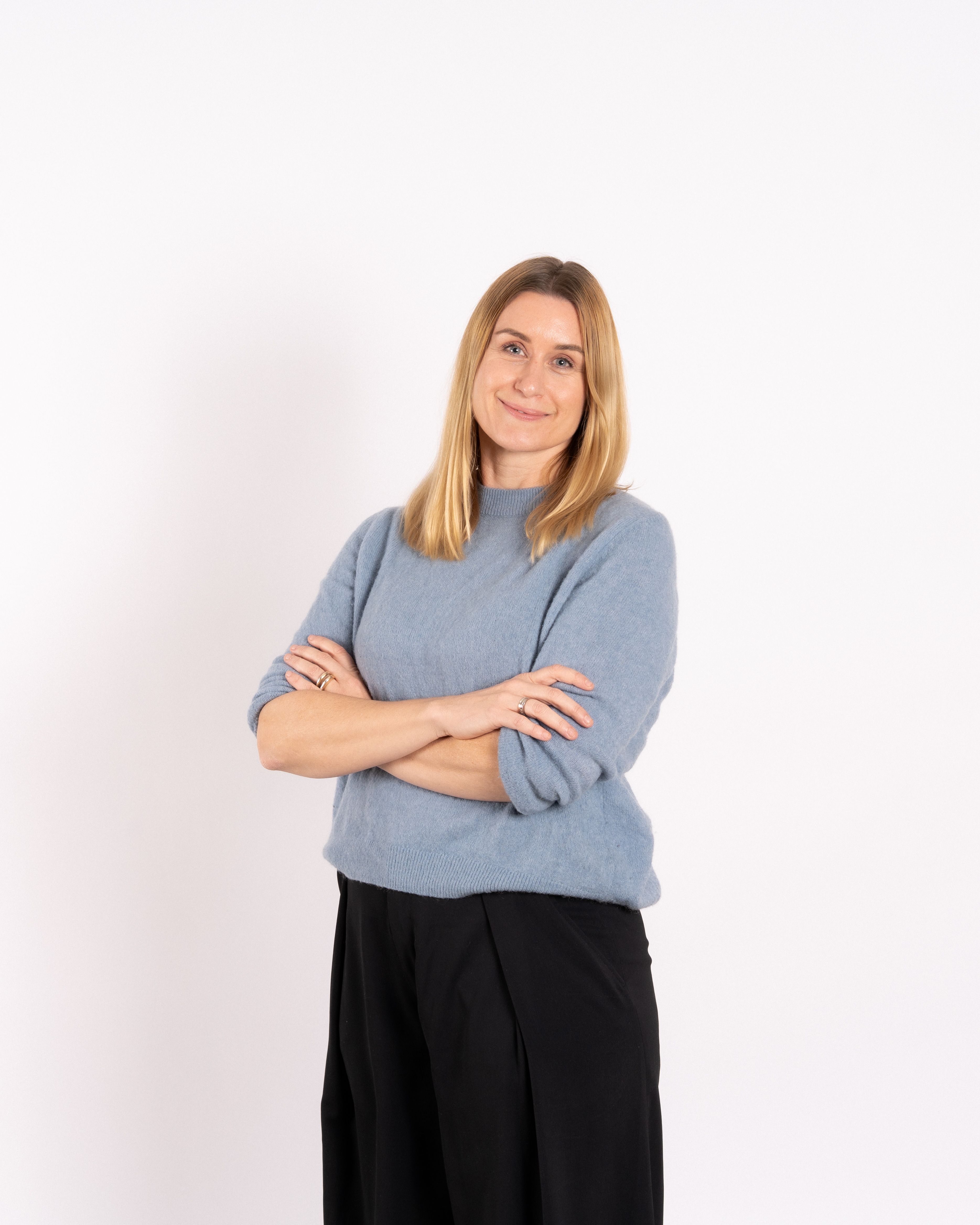 Image of Janne, with folded hands, lightly smiling