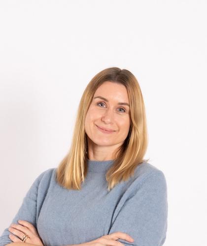 Image of Janne, with folded hands, lightly smiling