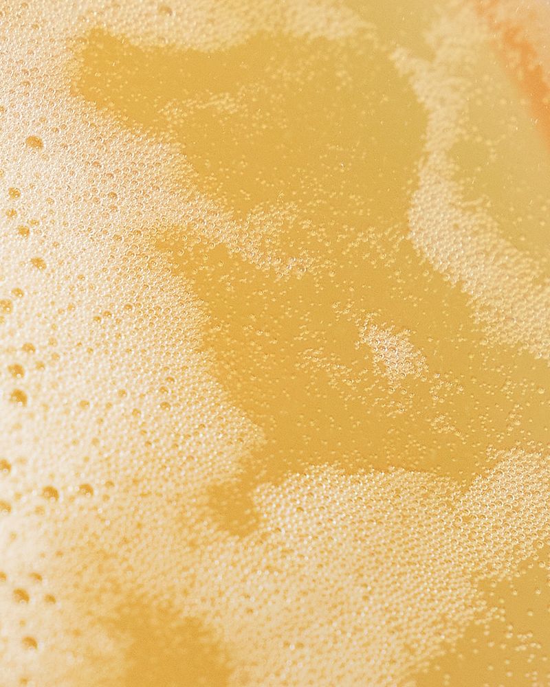Close-up of a golden, bubbly surface in a non-alcoholic, fermented drink SKOG from Villbrygg.
