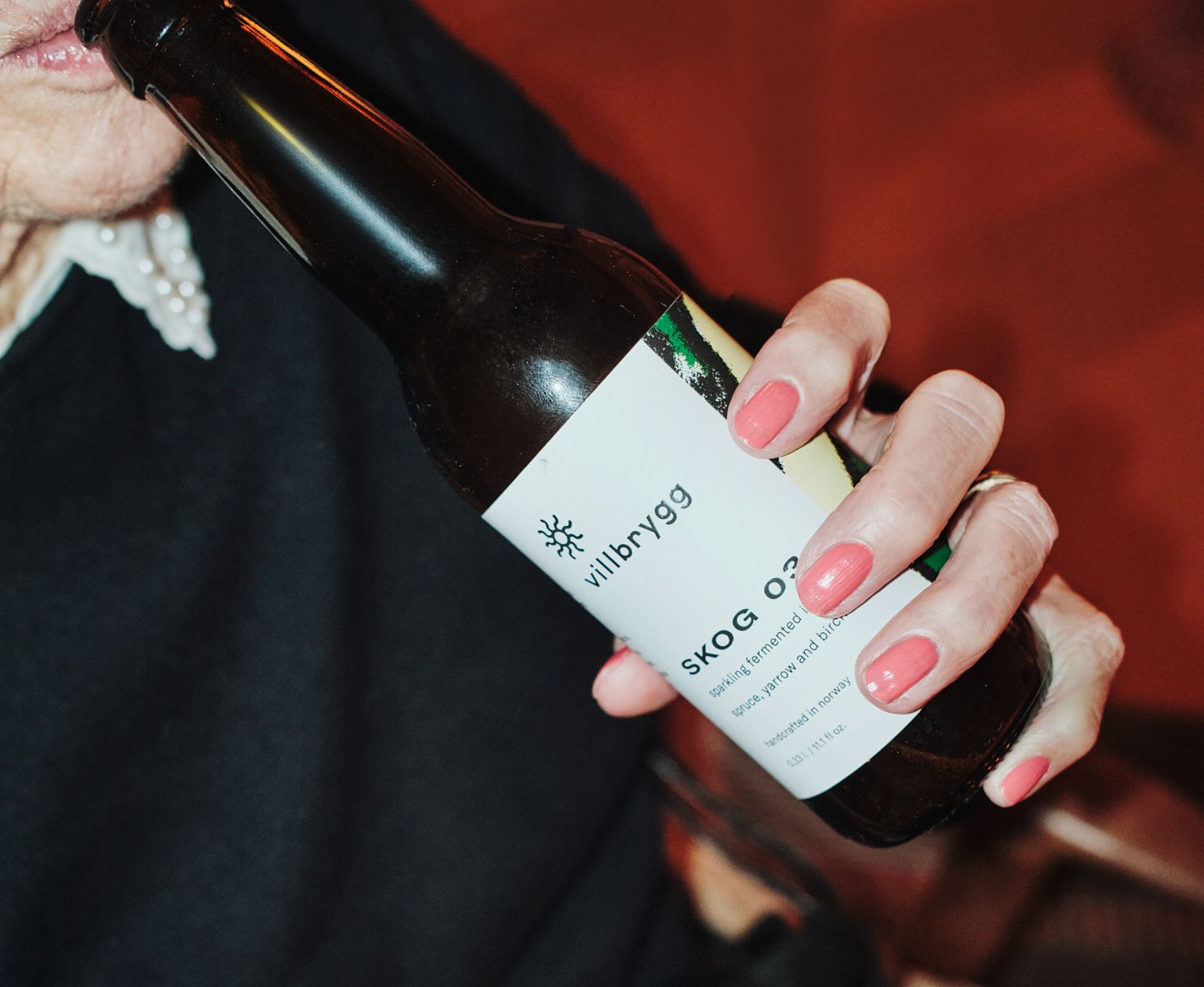 Eldre kvinne drikker SKOG 03 i 033L flaske