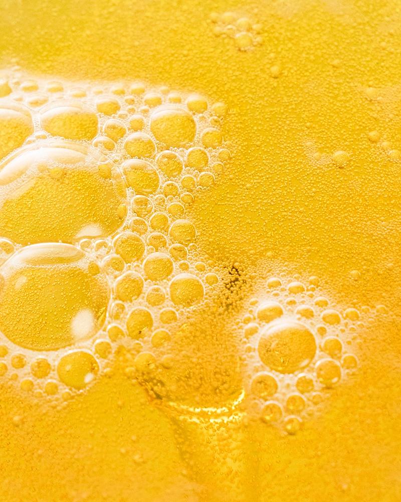 Close-up of the golden, bubbly surface of Villbrygg FLYT – an alcohol-free, fermented drink made with natural ingredients.
