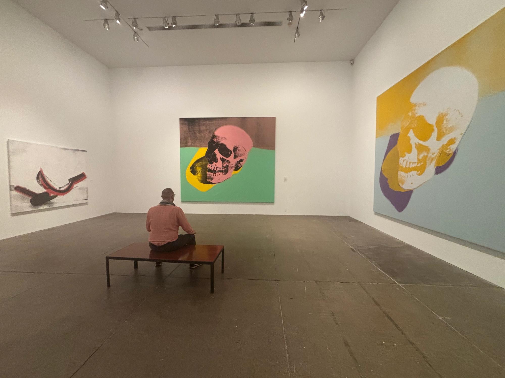 Sitting among Warhol skull and hammer / sickle paintings