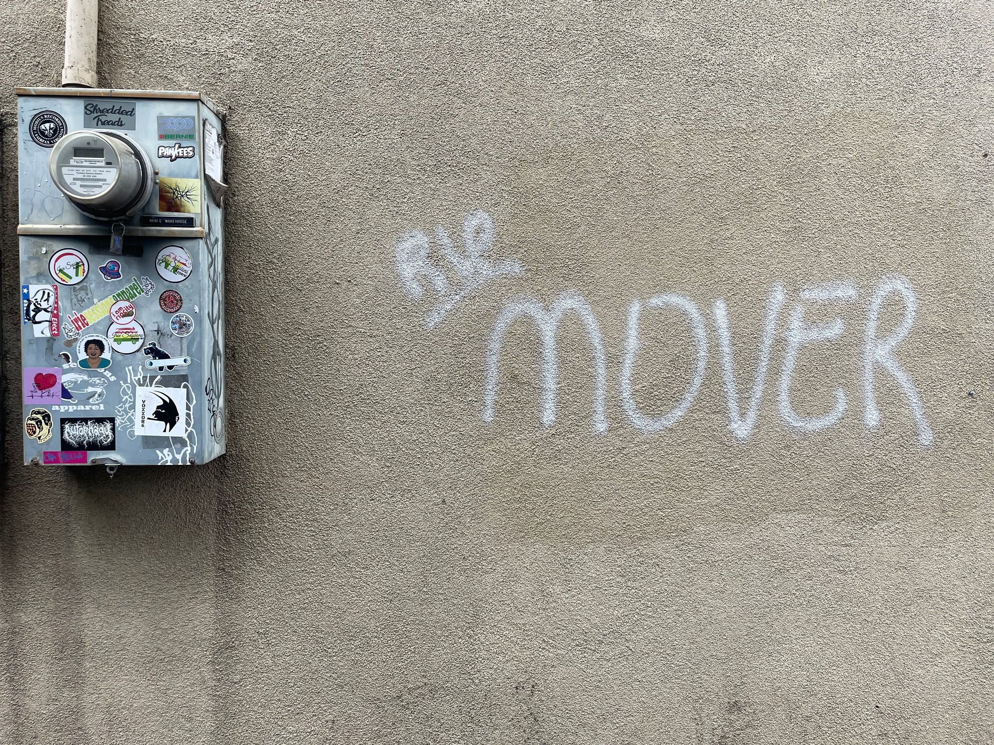 Graffiti reading "RIP Mover" spray painted on an alley wall.