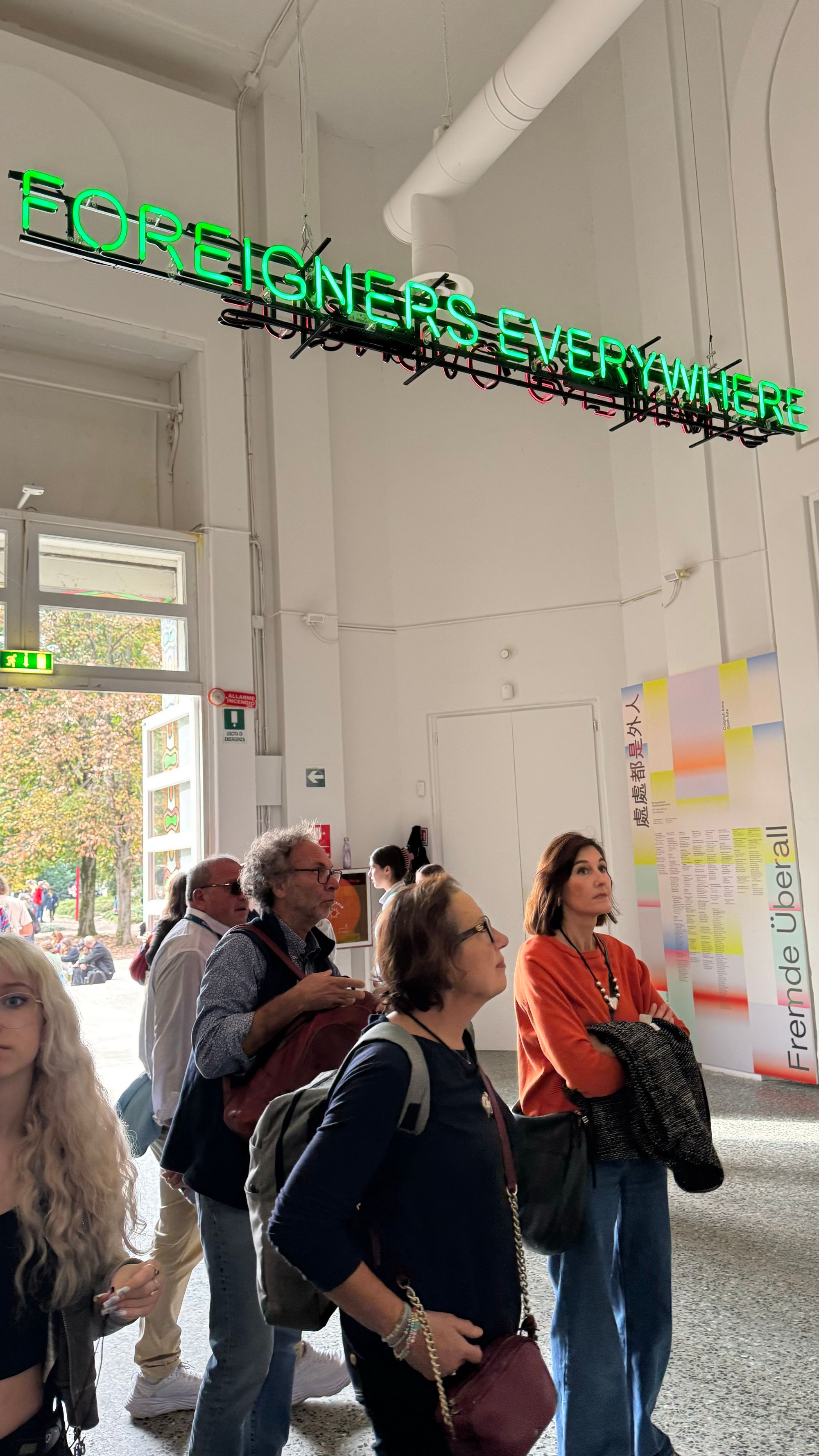 Neon sign reading “Foreigners Everywhere” in the main pavilion at the Bienalle