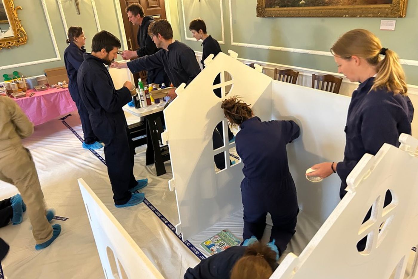 A team building and painting a wooden playhouse