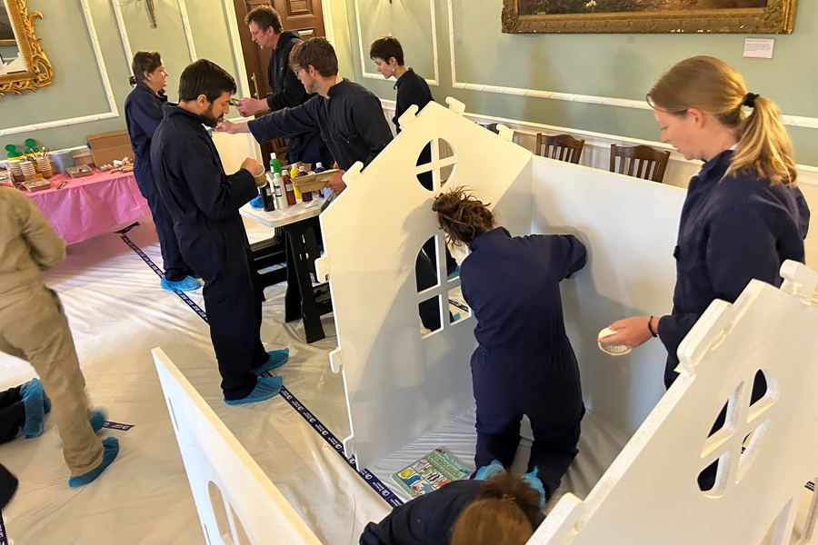 A team building and painting a wooden playhouse