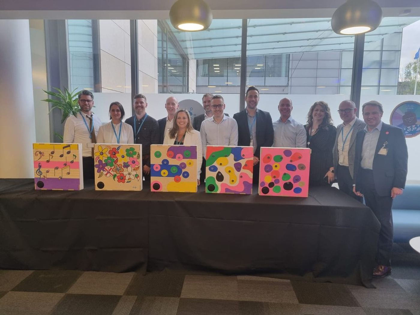 A team standing behind the music boxes they decorated