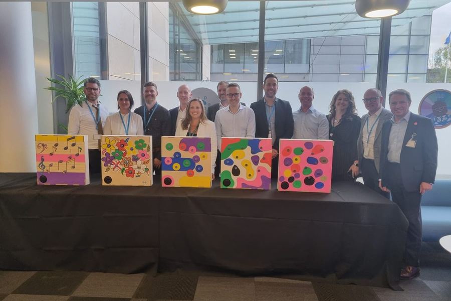 A team standing behind the music boxes they decorated
