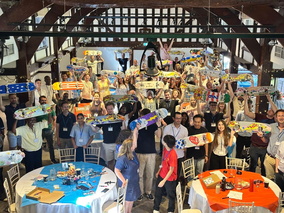 A hall of people holding up the skateboards they decorated